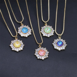 Detail of five sunflower pendants with colorful zircon stones on gold chains over black texture