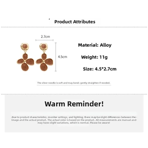 Vue macro des boucles d'oreilles fleur en émail marron avec dimensions 4.5cm x 2.7cm