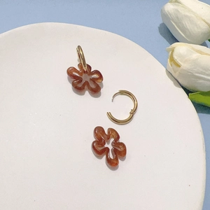 Vue macro détaillée de créoles en or 18K avec pendentifs fleurs ambre translucides