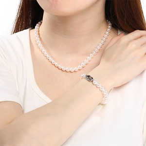 Vue détaillée d'un ensemble élégant collier et bracelet en perles de verre blanches