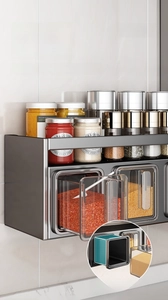 Detail of dark grey wall-mounted kitchen rack with transparent spice drawers and spoons