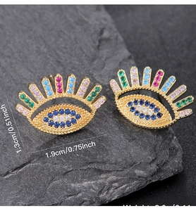 Detail view of evil eye earrings with colorful crystals on stone showing precise dimensions