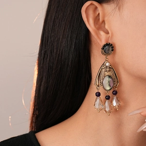 French vintage drop earrings with dark gems and sparkling crystals on female model