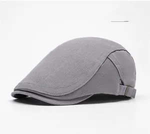Detail of grey flat cap with twill fabric texture and side metal buckle on white background