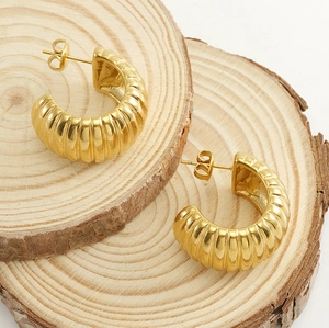 Détail de boucles d'oreilles C géométriques plaquées or 18 carats à texture rayée