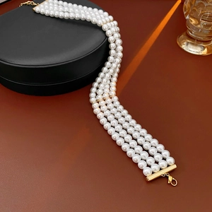 Bracelet multi-rangs en perles avec fermoir doré présenté sur un coffret à bijoux chic