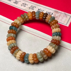 Close-up of multicolored pumpkin-shaped carved bodhi beads on a traditional bracelet