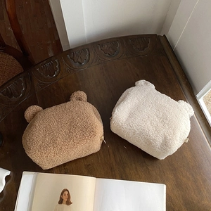Dettaglio delle borse per cosmetici a forma di orsetto in morbido peluche beige