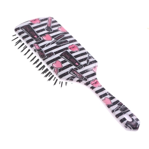 Detail of pink and black striped hairbrush with cartoon lipstick and mascara prints