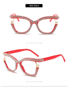 Detailed view of red cat-eye glasses with sparkling rhinestones and pearl embellishments