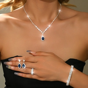 Close-up of elegant jewelry set with blue pear-cut gems and sparkling white zircons