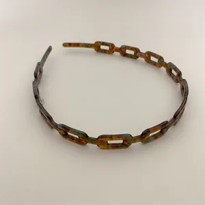 Macro view of tortoiseshell chain headband with resin link texture and vintage design