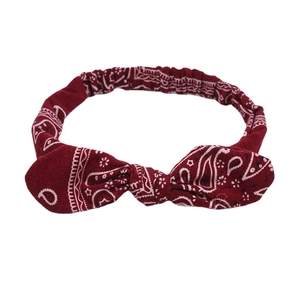 Elastic deep red bandana print headband with bunny ear knot design and white paisley motifs