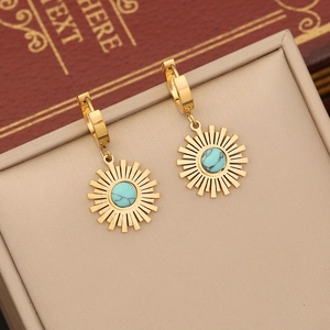 Golden sunburst earrings with turquoise stone displayed in a premium jewelry box