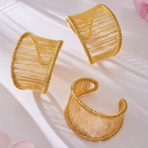 Trois bracelets larges en acier inoxydable plaqué or 18 carats avec fil métallique enroulé