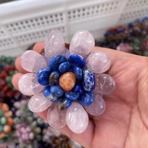 Handcrafted rose quartz and lapis lazuli crystal flower ornament held in hand