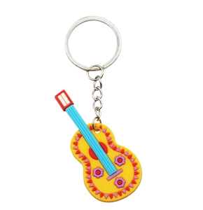 Close-up of a colorful yellow PVC guitar keychain with vibrant Mexican folk patterns