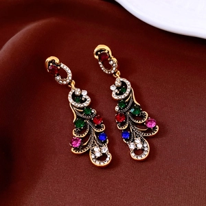 Close-up of vintage geometric earrings with multi-colored rhinestones on brown velvet