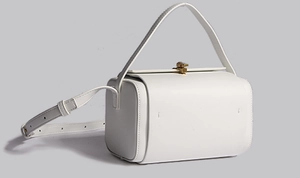 Vue détaillée du sac Boston en cuir blanc avec boucle métallique et bandoulière réglable