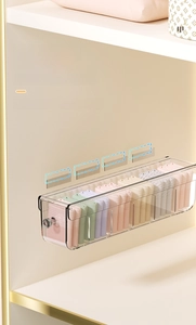Close-up of wall-mounted drawer organizer with transparent dividers for socks and underwear