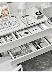 Close-up of clear acrylic drawer organizers for stationery on a minimalist desk
