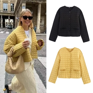 Détail de la veste matelassée jaune et noire avec col rond et boutonnage simple