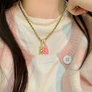 Dettaglio della collana a due strati con perle d'acqua dolce e ciondoli a orsetto