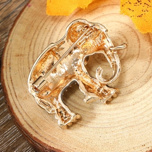 Detailed back view of a golden elephant brooch showing the pin clasp and metal texture