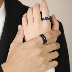 Close-up of black titanium couple rings with blue heart gemstone and pavé diamonds