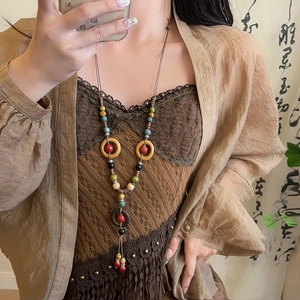 Close-up of ethnic beaded necklace featuring colorful ceramic beads and wood rings