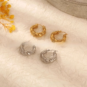 Vue macro de boucles d'oreilles créoles en or 18 carats et argent au design torsadé