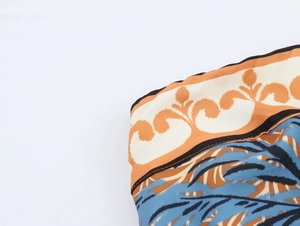 Detailed close-up of vibrant coconut tree print fabric with a smooth satin texture
