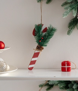 Detailed Christmas candy cane ornament with pine needles, cones and berries on rustic twine