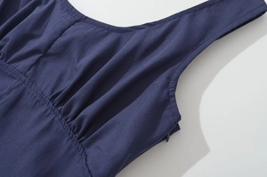 Detail view of the deep blue sleeveless dress fabric texture and side pleat stitching