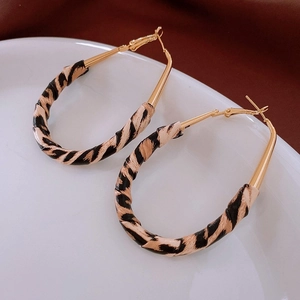Vue détaillée des boucles d'oreilles dorées en U avec incrustation motif léopard