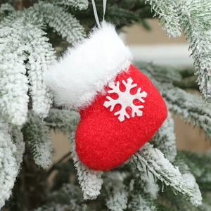 Mini red plush Christmas stocking ornament with snowflake on snowy tree branch