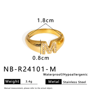 Macro shot of 18K gold plated stainless steel letter M ring with cubic zirconia stones