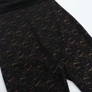 Close-up of black lace fabric and beige lining on a backless bodysuit garment