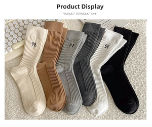 Detail view of multi-color ribbed cotton crew socks with small bow embroidery accents