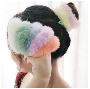 Macro detail of plush elastic hair ties in various vibrant colors on a soft background