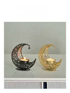 Detail of moon-shaped metal candle holders in gold and black with star pendants