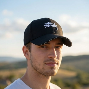 Outdoor portrait of a black cotton baseball cap with Amikey embroidery and extended brim
