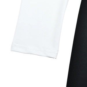 Close-up of white cuff stitching and black knit fabric texture on the split dress