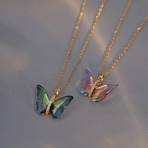 Iridescent butterfly pendant necklaces in green and purple on golden titanium chains