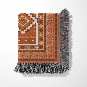 Detailed view of bohemian woven blanket with geometric floral patterns and fringe edges