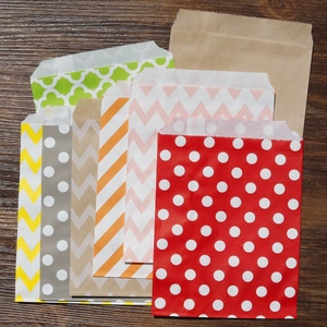 Vista piatta di sacchetti regalo in carta kraft colorata con pois e onde