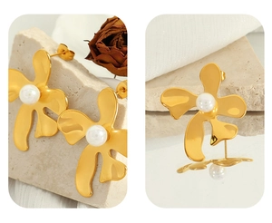Gros plan sur boucles d'oreilles fleur dorée vintage avec perle et détails ciselés