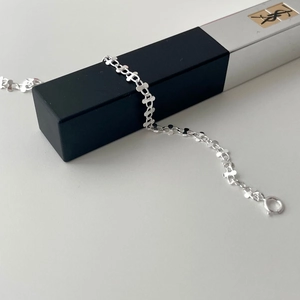 Macro detail of S925 sterling silver twisted link bracelet with classic spring clasp