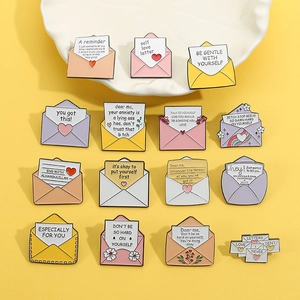 Collezione di spille in smalto a forma di busta con frasi positive su sfondo giallo