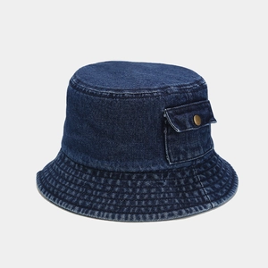 Close-up of deep blue denim fisherman hat featuring a utility pocket and metal snap button